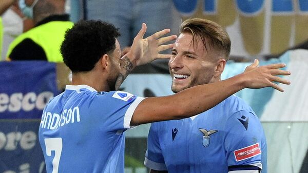 Lazio's Brazilian forward Felipe Anderson (L) celebrates with Lazio's Italian forward Ciro Immobile after scoring during the Italian Serie A football match Lazio vs AS Roma at the Olympic stadium in Rome on September 26, 2021. (Photo by Vincenzo PINTO / AFP)
