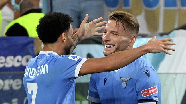 Lazio's Brazilian forward Felipe Anderson (L) celebrates with Lazio's Italian forward Ciro Immobile after scoring during the Italian Serie A football match Lazio vs AS Roma at the Olympic stadium in Rome on September 26, 2021. (Photo by Vincenzo PINTO / AFP)