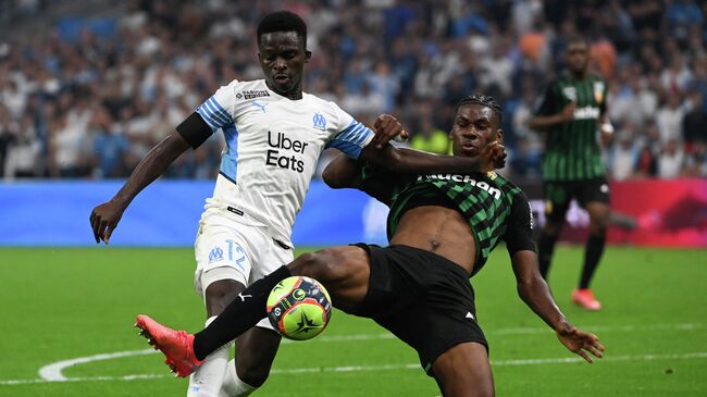 Marseille's Senegalese forward Bamba Dieng is tackled in the penalty area by Lens' French defender Christopher Maurice Wooh and obtains a penalty during the French L1 football match between Olympique Marseille (OM) and RC Lens at Stade Velodrome in Marseille, southern France on September 26, 2021. (Photo by Christophe SIMON / AFP)