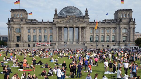 Жители Берлина на лужайке на площади Республики перед зданием Будестага в день выборов в парламент Германии