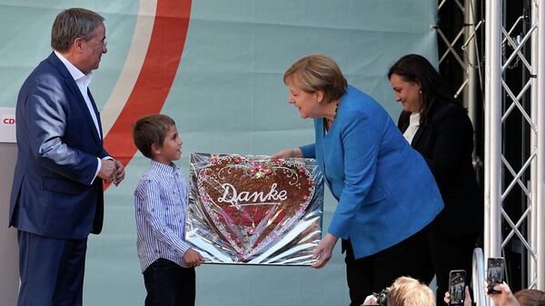 Канцлеру Ангеле Меркель преподносят традиционные имбирные пряники с надписью в преддверии всеобщих выборов в Германии в Аахене, Германия