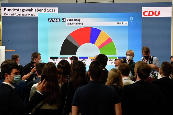 Сторонники и члены Христианско-демократического союза (ХДС) смотрят на результаты голосования в штаб-квартире Христианско-демократического союза в Берлине 