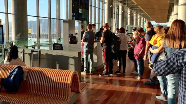 Туристы в очереди на посадку в аэропорту Даламан в Турции