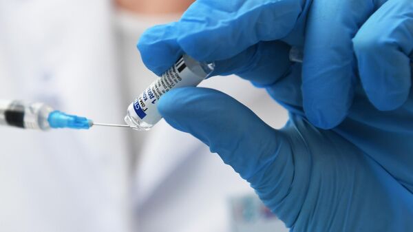 Медицинский работник набирает в шприц препарат от коронавирусной инфекции Гам-Ковид-Вак (Спутник V) 