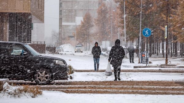 Прохожие на одной из улиц во время снегопада в Нерюнгри