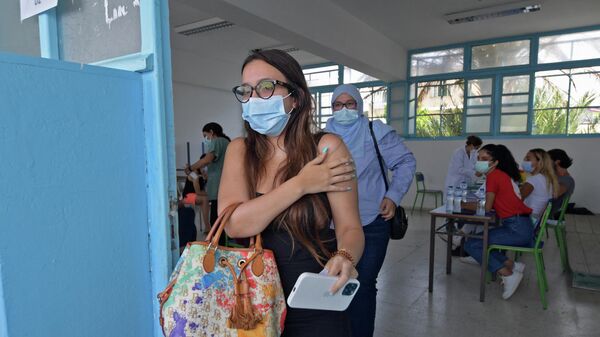 Девушка после вакцинации от коронавируса препаратом Moderna в Тунисе
