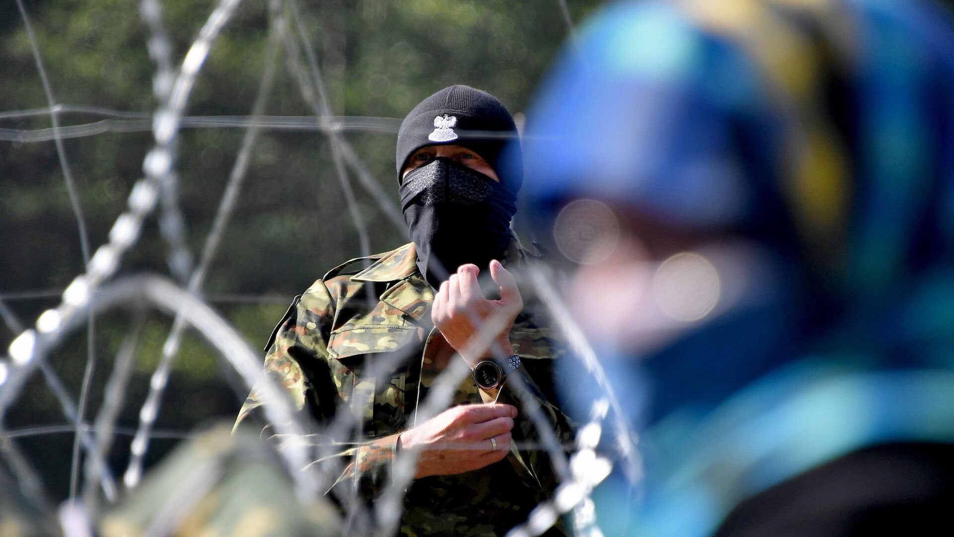 Польский пограничник наблюдает за лагерем беженцев из Афганистана на белорусско-польской границе. - РИА Новости, 1920, 14.10.2021