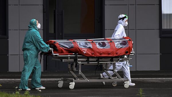 Медицинские сотрудники транспортируют пациента на каталке в Республиканскую клиническую инфекционную больницу в Казани, где возобновлен прием пациентов с COVID-19