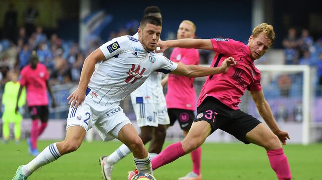 Montpellier's French defender Nicolas Cozza (R) fights for the ball with Strasbourg's French defender Frederic Guilbert (L) during the French L1 football match between Montpellier and Strasbourg at the Mosson stadium in Montpellier, southern France, on October 2, 2021. (Photo by Sylvain THOMAS / AFP)