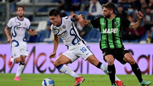 Inter Milan's Argentine forward Joaquin Correa (L) fights for the ball with Sassuolo's Italian forward Domenico Berardi (R) during the Italian Serie A football match between Sassuolo and Inter Milan at the Citta del Tricolore Stadium in Reggio Emilia on October 2, 2021. (Photo by MIGUEL MEDINA / AFP)