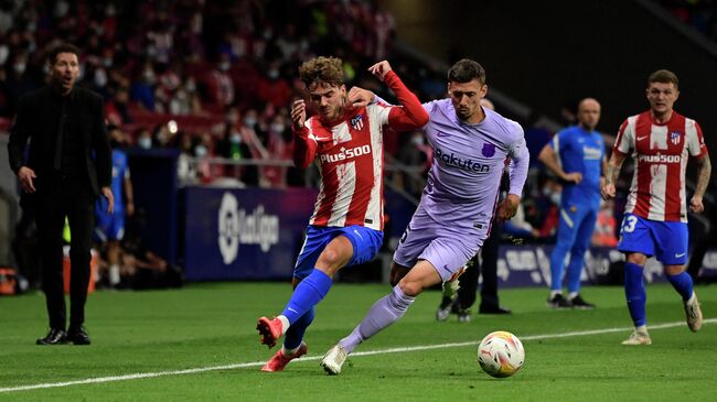 Atletico Madrid's French midfielder Antoine Griezmann (L) fights for the ball with Barcelona's French defender Clement Lenglet during the Spanish League football match between Club Atletico de Madrid and FC Barcelona at the Wanda Metropolitano stadium in Madrid on October 2, 2021. (Photo by JAVIER SORIANO / AFP)