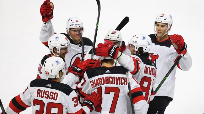 BRIDGEPORT, CONNECTICUT - OCTOBER 02: Yegor Sharangovich #17 and the New Jersey Devils celebrate his game winning goal at 3:36 of overtime against the New York Islanders during a preseason game at the Webster Bank Arena at Harbor Yard on October 02, 2021 in Bridgeport, Connecticut. The Devils defeated the Islanders 2-1 in overtime.   Bruce Bennett/Getty Images/AFP (Photo by BRUCE BENNETT / GETTY IMAGES NORTH AMERICA / Getty Images via AFP)