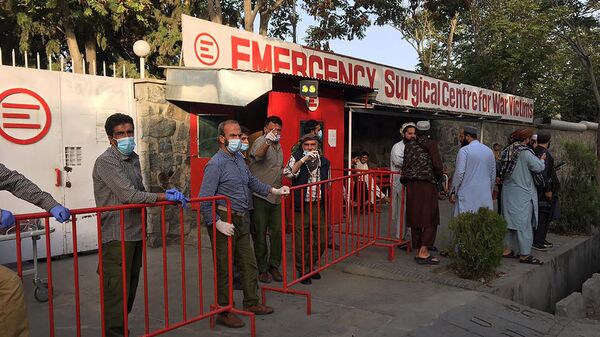 Медицинские работники стоят у входа в больницу, ожидая приема пострадавших от взрыва у мечети в Кабуле