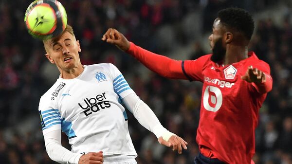 Lille's French midfielder Benjamin Andre (R) and Marseille's Turkish forward Cengiz Under fight for the ball with during the French L1 football match between Lille OSC and Marseille at the Pierre-Mauroy stadium in Villeneuve-d'Ascq, northern France on October 3, 2021. (Photo by DENIS CHARLET / AFP)