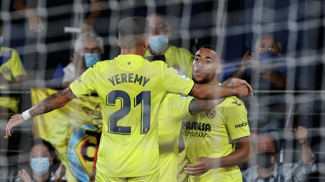 Villarreal's Dutch midfielder Arnaut Danjuma Groeneveld (R) celebrates with teammates after scoring his team's second goal during the Spanish League football match between Villarreal CF and Real Betis at La Ceramica stadium in Vila-real on October 3, 2021. (Photo by JOSE JORDAN / AFP)