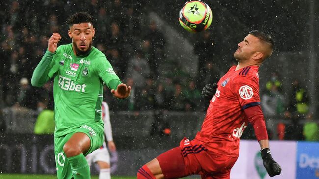 Saint-Etienne's Gabonese forward Denis Bouanga (L) fights for the ball with Lyon's Portuguese goalkeeper Anthony Lopes (R) during the French  football match between AS Saint-Etienne and Olympique Lyonnais at the Geoffroy Guichard stadium in Saint-Etienne, central France on October 3, 2021. (Photo by PHILIPPE DESMAZES / AFP)