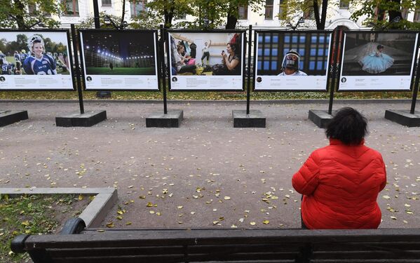 Женщина рассматривает фотографии на выставке работ финалистов фотоконкурса им. А. Стенина на Гоголевском бульваре в Москве