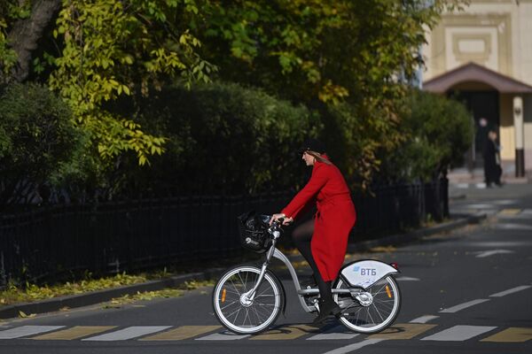 Девушка катается на велосипеде вблизи Новодевичьего монастыря в Москве