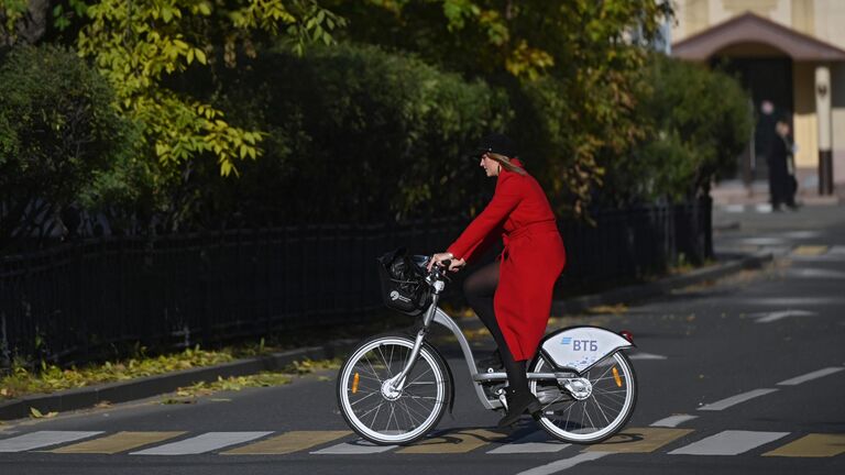 Девушка катается на велосипеде вблизи Новодевичьего монастыря в Москве
