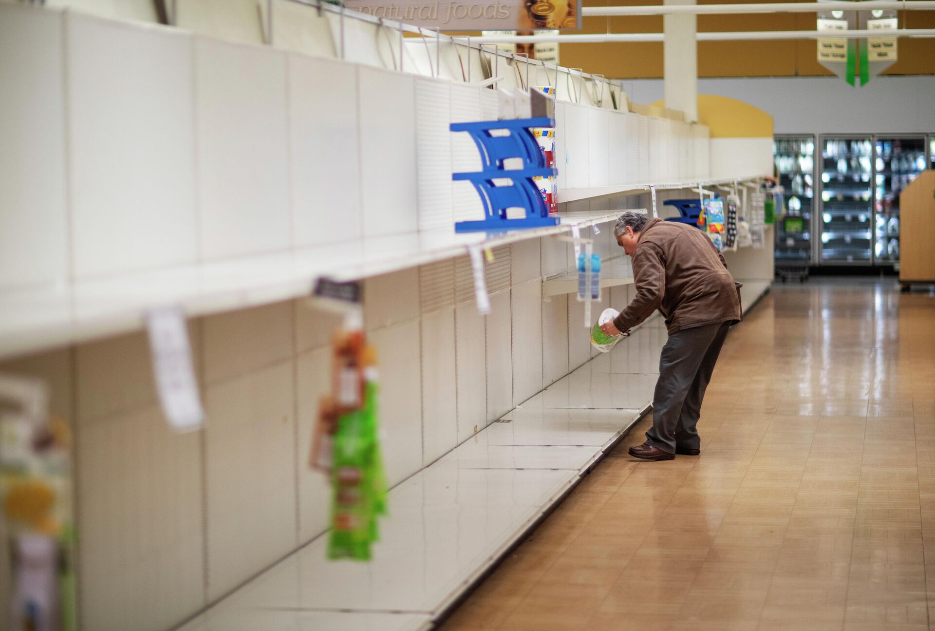 Мужчина берет с пустой полки пачку туалетной бумаги в супермаркете в Род-Айленд. - РИА Новости, 1920, 05.10.2021