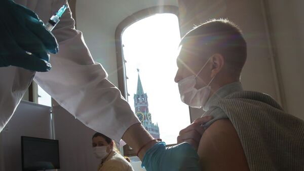 Мужчина делает прививку в пункте вакцинации от COVID-19 в ГУМе в Москве