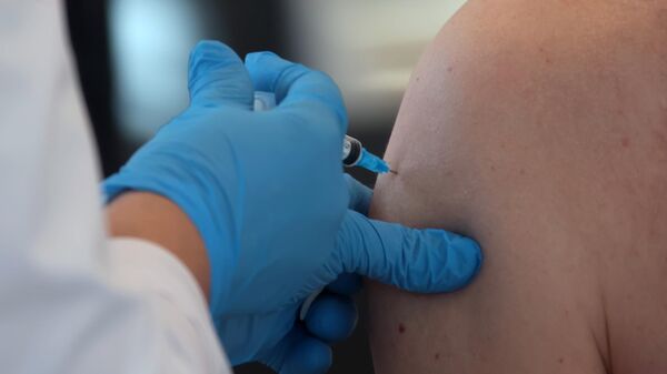 Мужчина делает прививку в пункте вакцинации от COVID-19