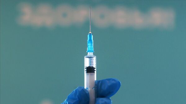 Медицинский работник держит в руках шприц с вакциной