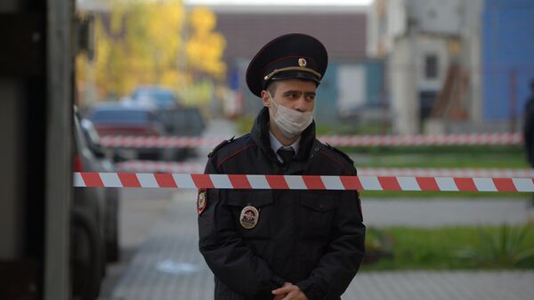 Сотрудник полиции у жилого дома на улице Левобережной в Москве, где были обнаружены тела женщины и двух детей