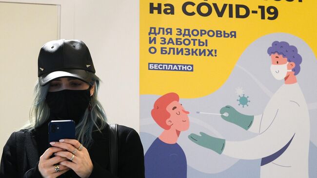 Девушка возле пункта для сдачи экспресс-теста на COVID-19 в ГУМе