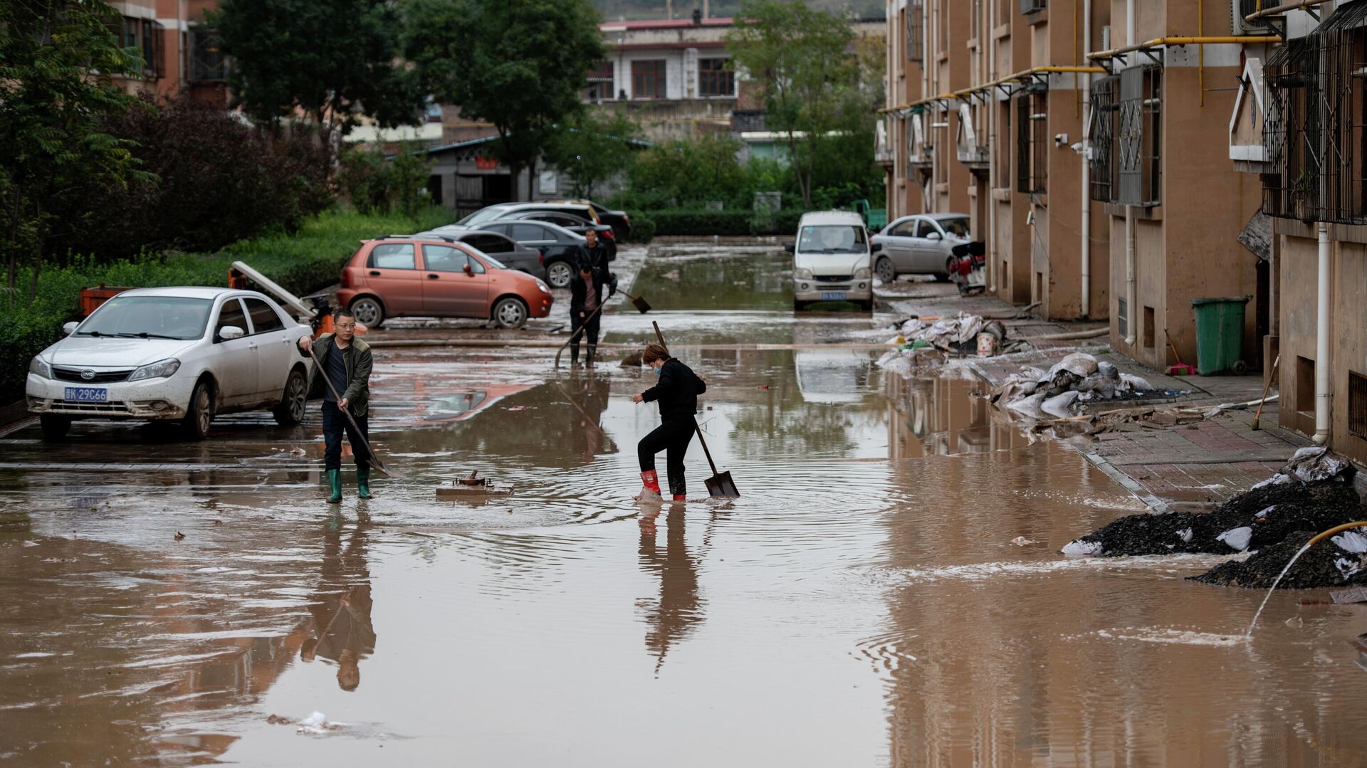 Жители расчищают двор жилого дома после проливных дождей в провинции Шаньси, Китай - РИА Новости, 1920, 12.10.2021
