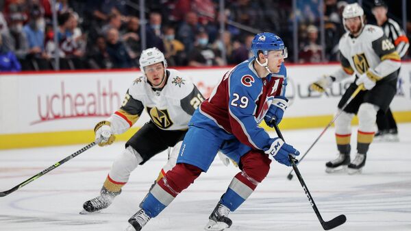 Oct 5, 2021; Denver, Colorado, USA; Colorado Avalanche center Nathan MacKinnon (29) controls the puck against Vegas Golden Knights center Mattias Janmark (26) in the first period at Ball Arena. Mandatory Credit: Isaiah J. Downing-USA TODAY Sports