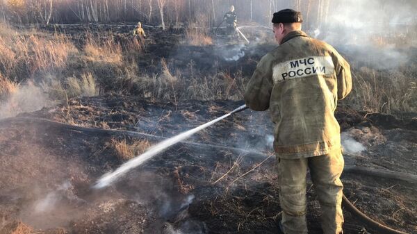 Пожарный у тлеющего торфяника на юге Екатеринбурга