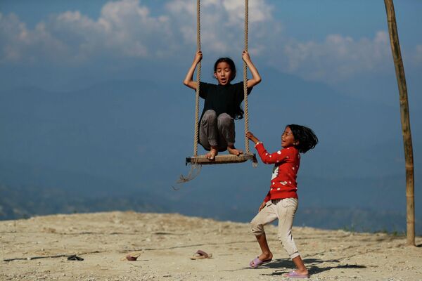 Девочка катается на качелях на окраине Катманду