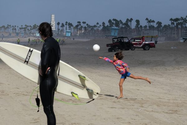 Девочка играет в мяч на пляже в Калифорнии 
