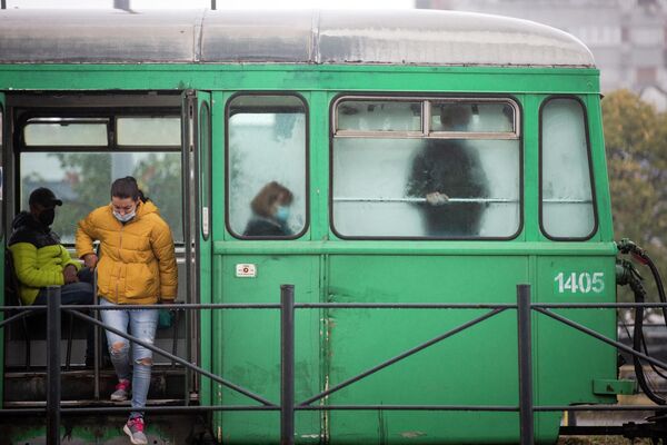 Пассажиры в защитных масках выходят из трамвая в Белграде, Сербия 