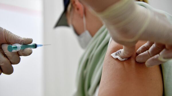 Мужчина во время вакцинации в прививочном пункте