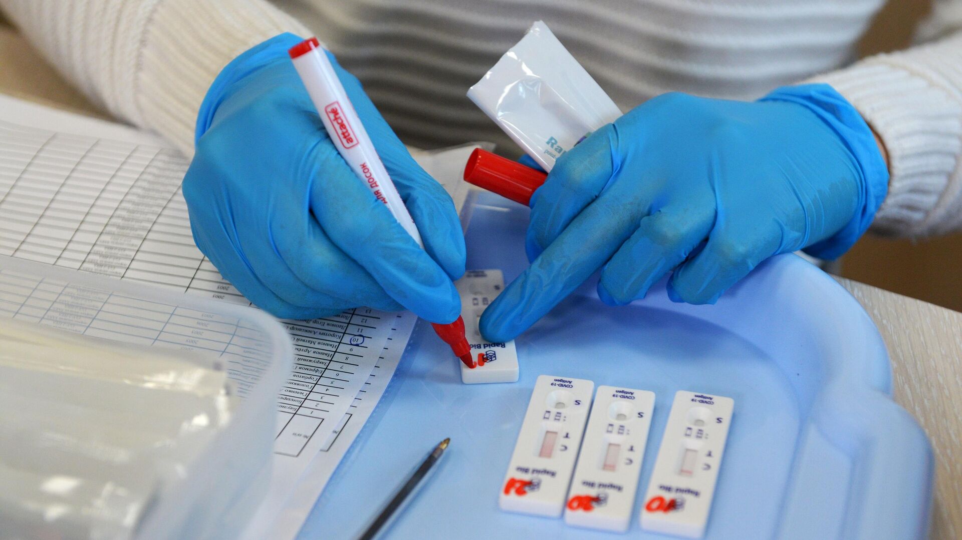 Медицинский сотрудник маркирует тест-полоски во время экспресс-тестирования на Covid-19 в московской школе - РИА Новости, 1920, 15.10.2021