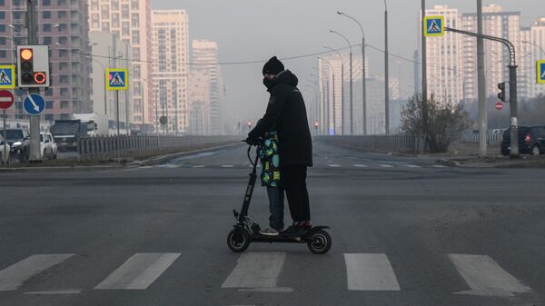 Мужчина с ребенком катаются на электросамокате в Екатеринбурге