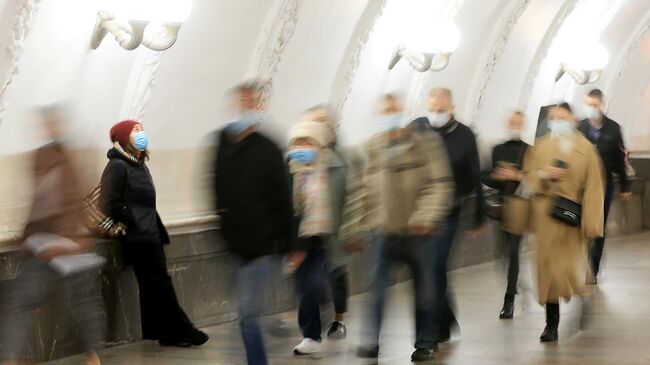 Пассажиры в защитных масках на одной из станций Московского метрополитена