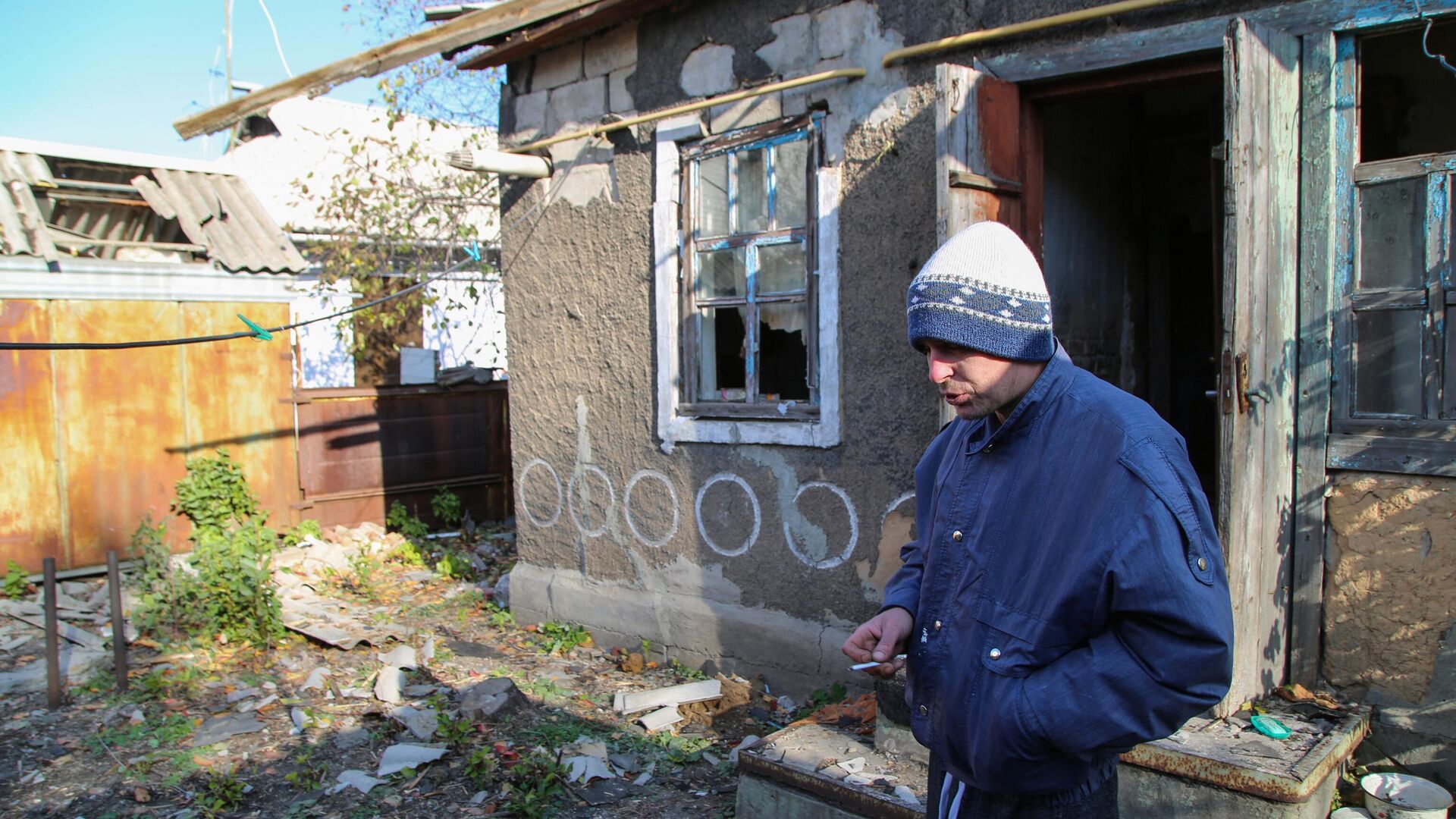 42-летний житель Донецка у своего дома на улице Дружбы, в крышу которого попал снаряд - РИА Новости, 1920, 29.11.2021