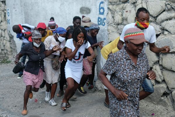 Демонстранты бегут от слезоточивого газа, примененного полицией, в Порт-о-Пренсе