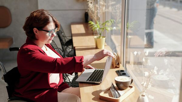 Женщина с инвалидностью с ноутбуком в кафе