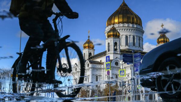 Велосипедист рядом с храмом Христа Спасителя в Москве