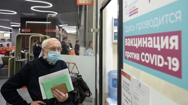Мужчина стоит в очереди в кабинет вакцинации от COVID-19 в торгово-развлекательном центре Columbus в Москве