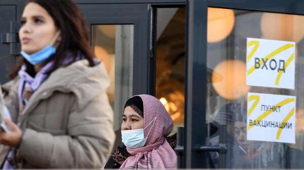 Девушки выходят из круглосуточного пункта вакцинации от Covid-19 у торгово-развлекательного  центра МЕГА в Казани