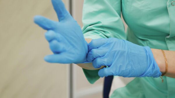 Медсестра поправляет медицинские перчатки