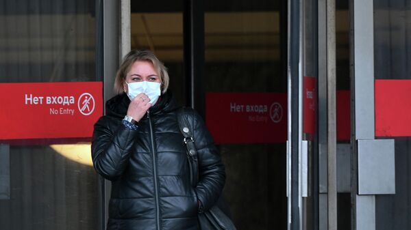 Женщина в медицинской маске выходит из станции метро Маяковская Московского метрополитена