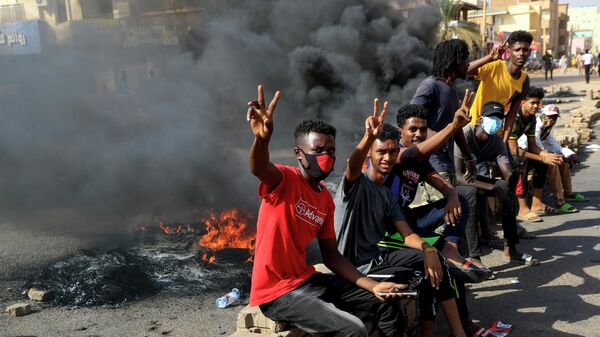 Участники акции протеста жгут шины на улице в Хартуме, Судан