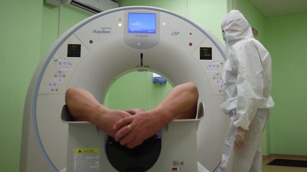 Медицинский сотрудник готовит пациента к проведению компьютерной томографии 