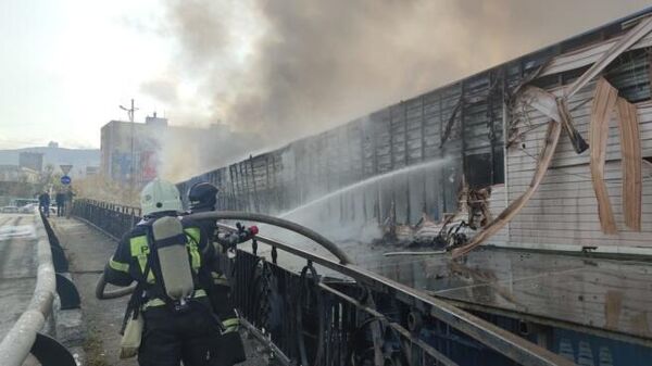 Сотрудники противопожарной службы тушат Некрасовский рынок во Владивостоке